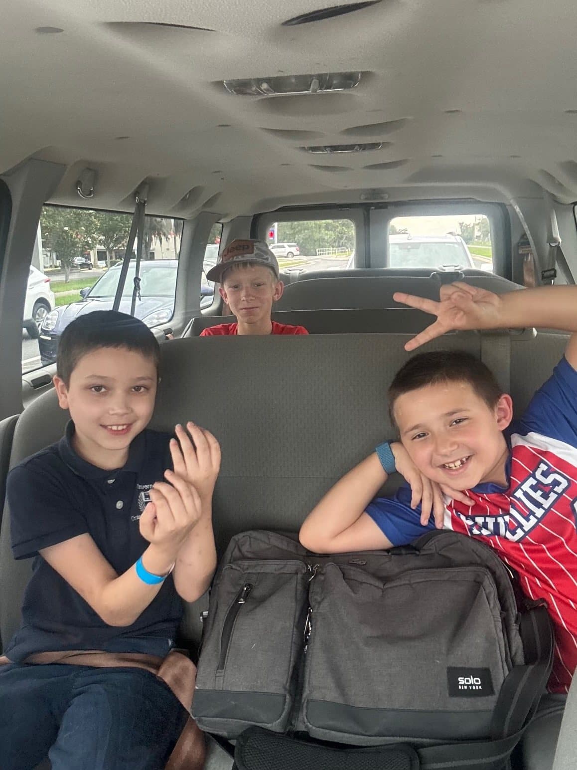 Boys grinning in the back of the church van