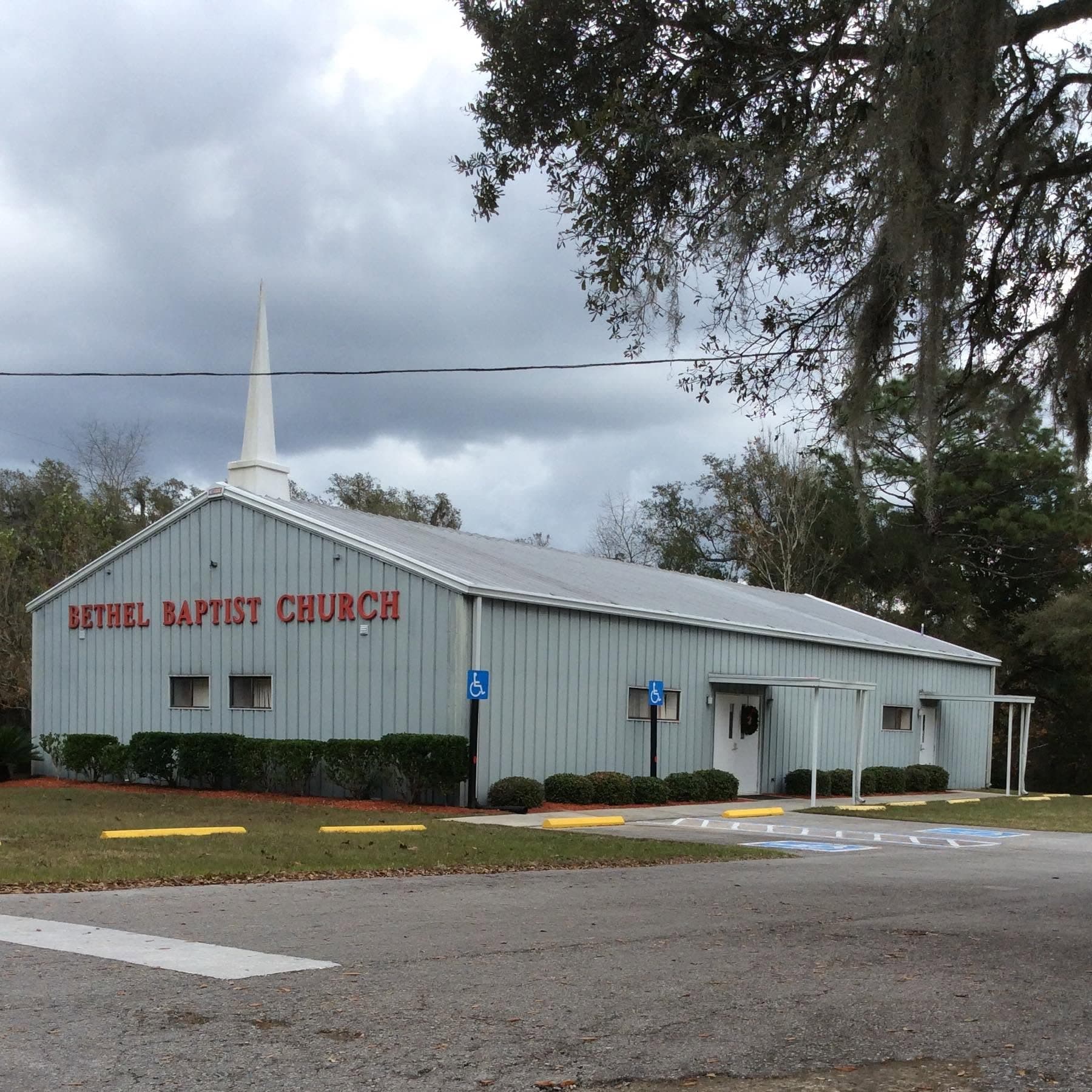 The church before the rebuild, pale blue siding with red letters under Spanish moss