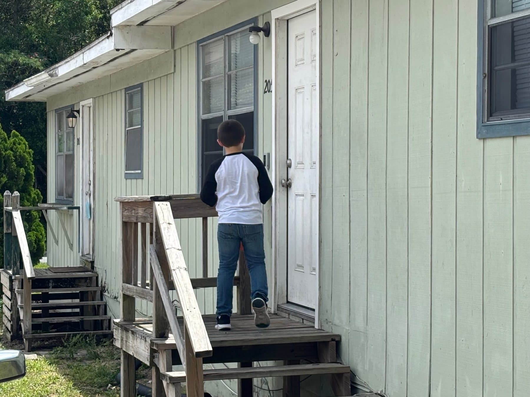 A boy knocking on a door during door-to-door outreach