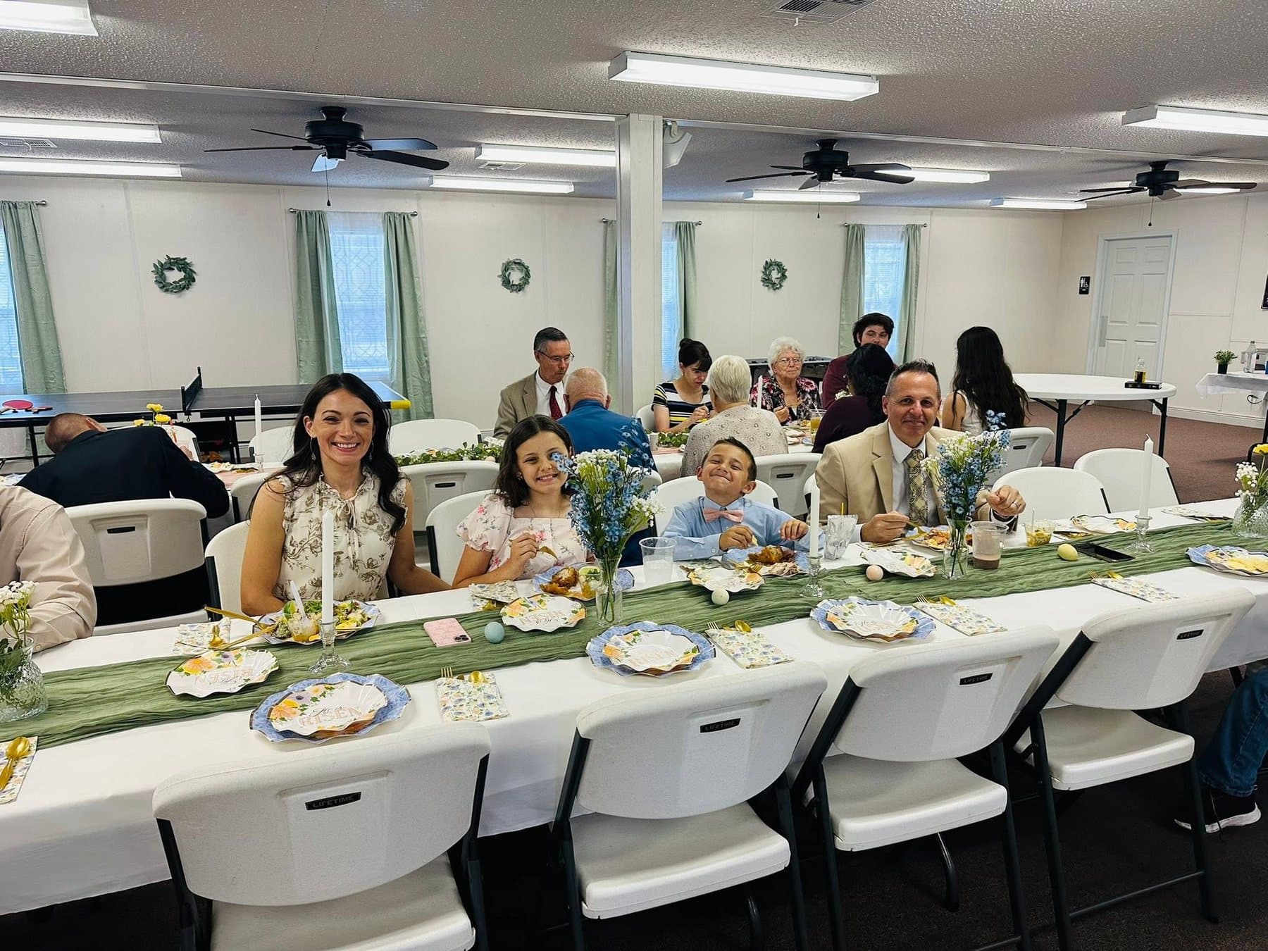 The church family around long tables in the fellowship hall at Sunday lunch