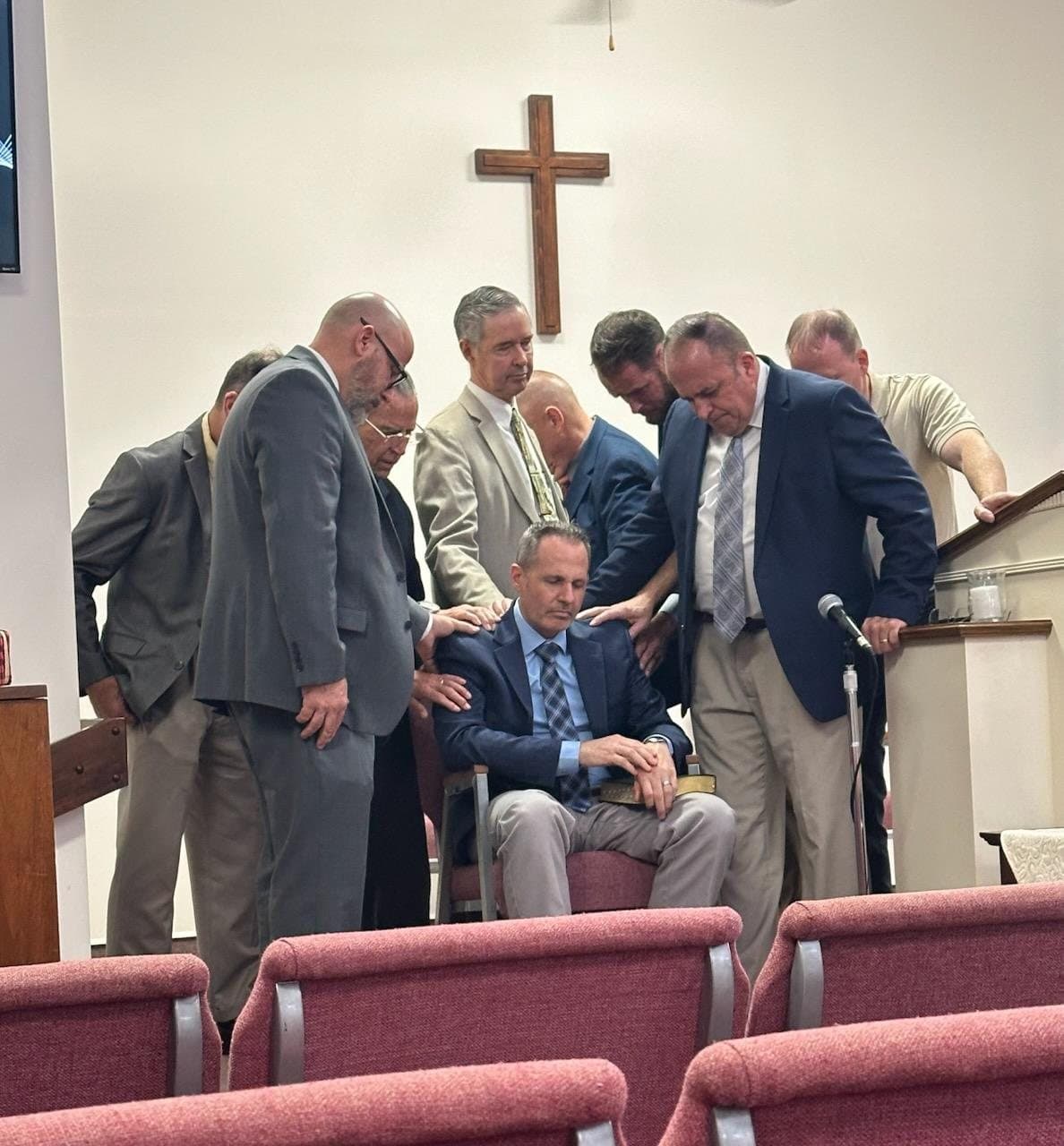 Pastors laying hands on Brandon Bankert at his ordination, December 2025