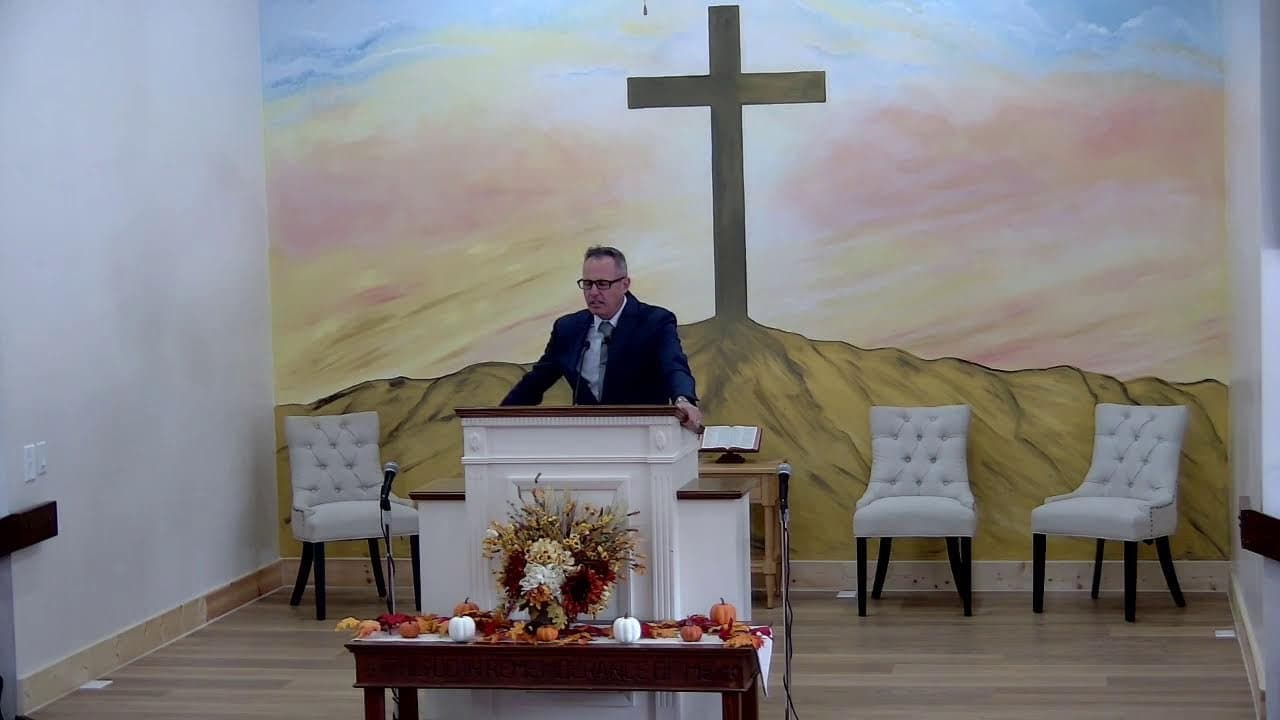 Pastor Bankert preaching from the pulpit in front of the mural, from the Sunday livestream