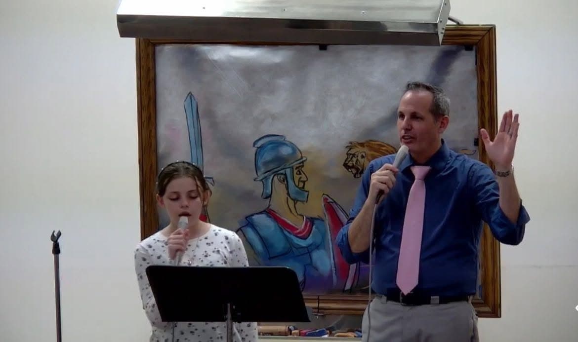 Pastor Bankert and his wife singing at the front of the sanctuary