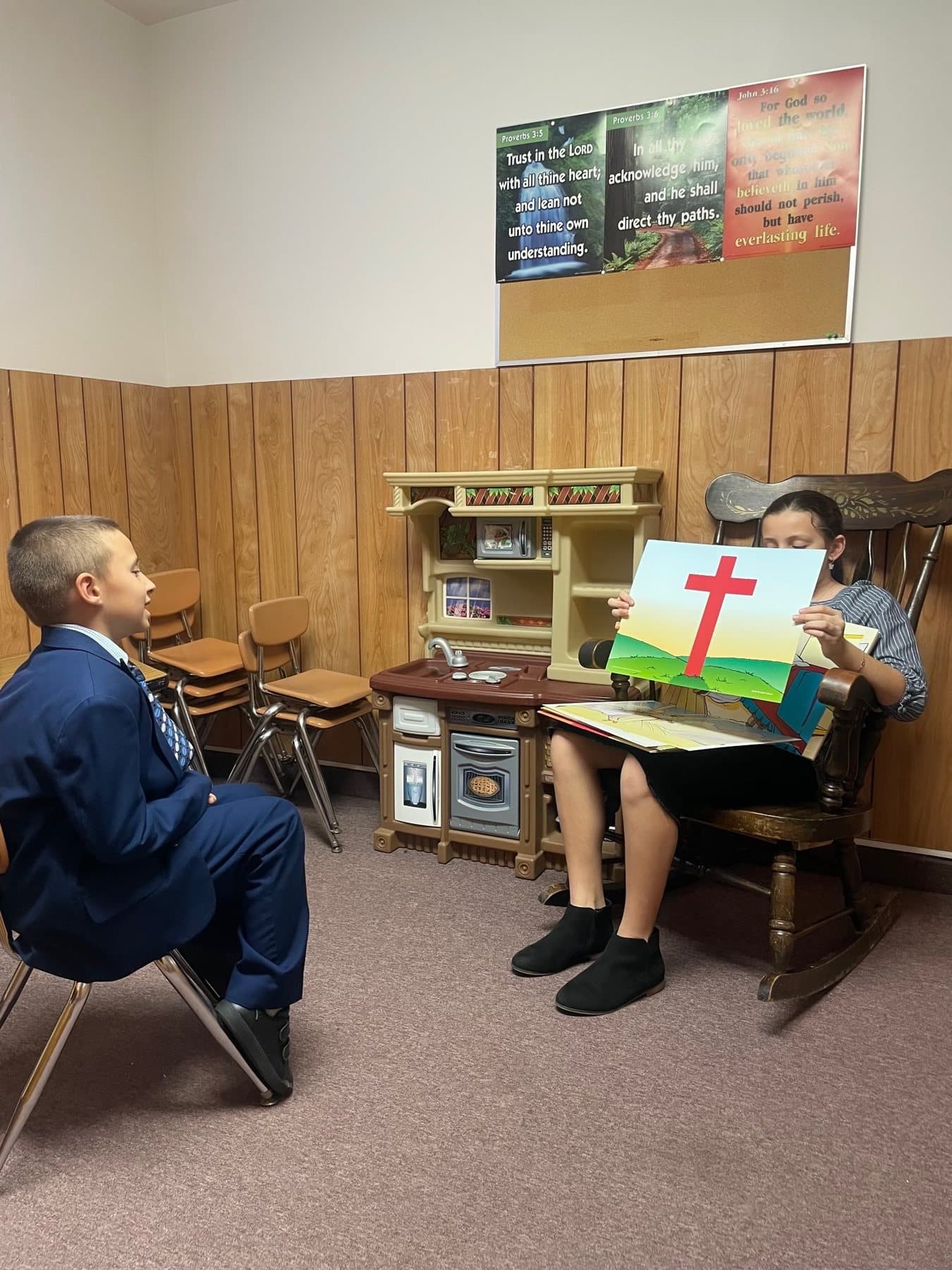 Children in the Bible Explorers classroom with a painting of the cross